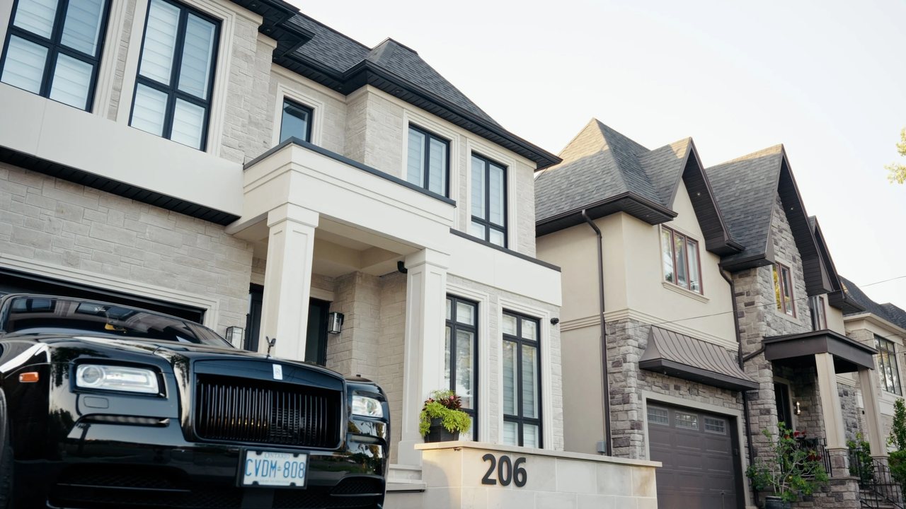 Stone and brick home with tall windows and a landscaped front entrance.